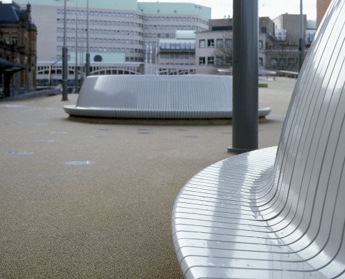 cirkelvormige banken stadsbalkon Groningen stationsplein zilverkleurige gebogen stalen strips overdag, meubilairontwerp door ipv Delft