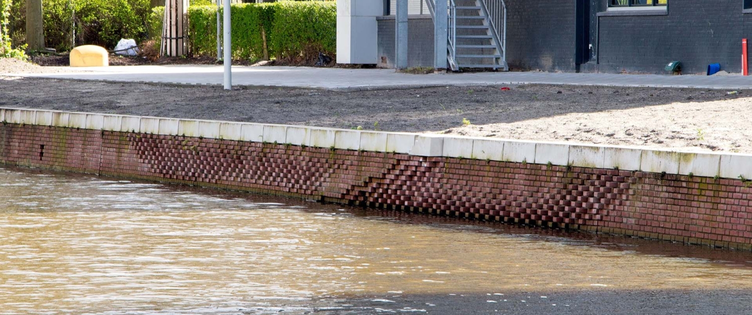 eendentrap, eendennestkast, uitstekende stenen en kalkrijke voegen in natuurinclusieve gemetselde kademuur
